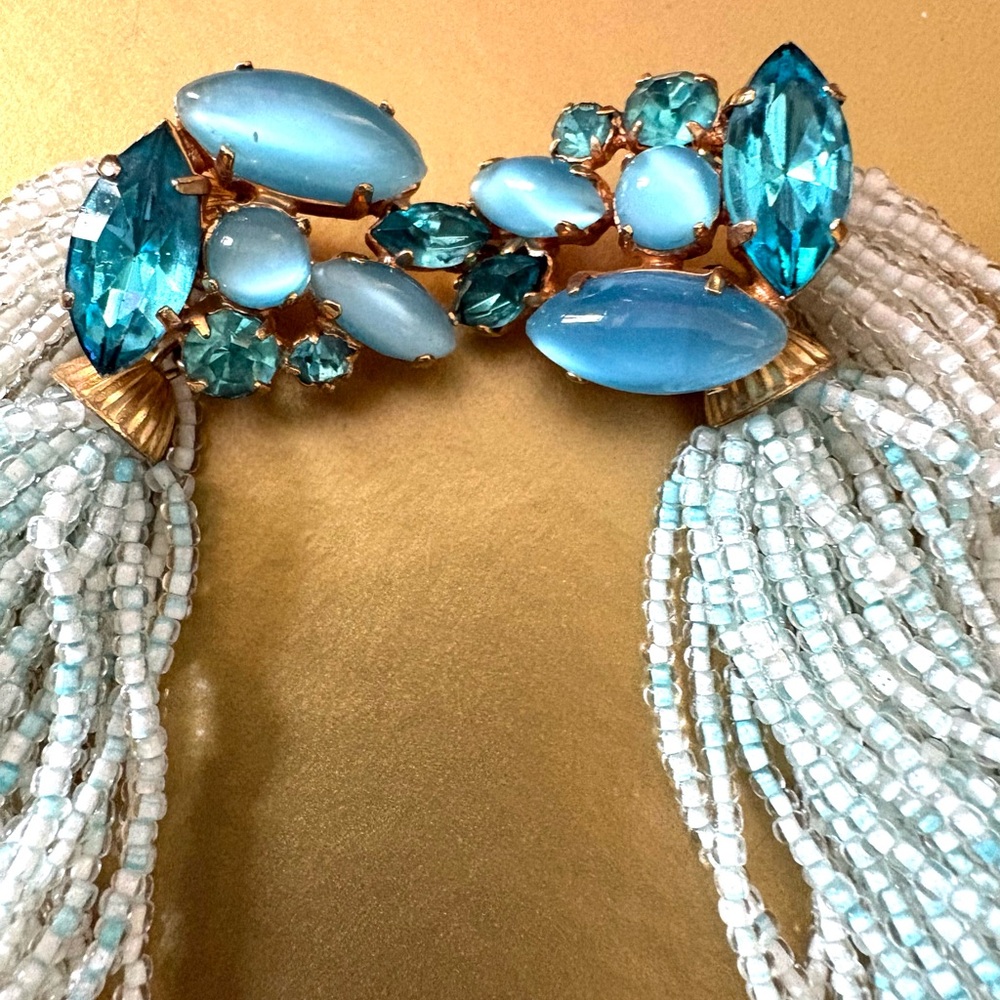 Vintage statement necklace is beaded with jewel tones of ocean blues.